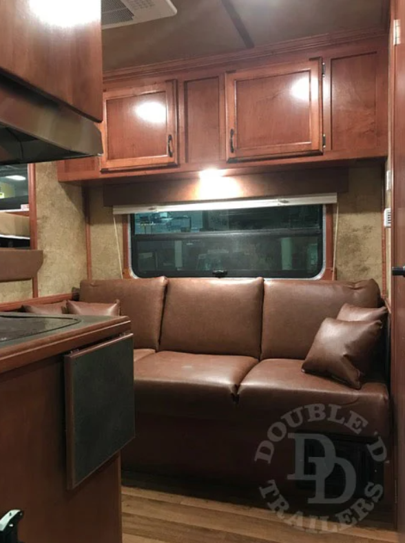 A convertible dinette sofa inside of a Double D Trailers living quarters horse trailer. 