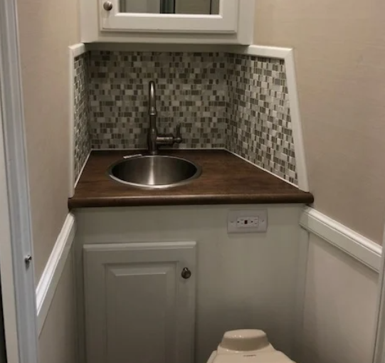 The sink and toilet area inside of a Double D Trailers living quarters horse trailer. 