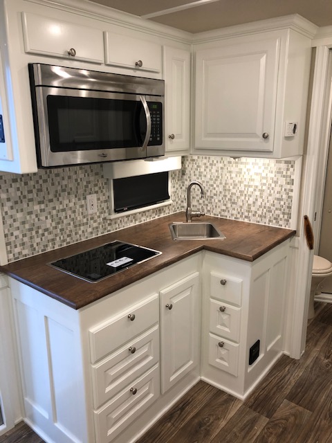 Recessed cooktop inside of a living quarters horse trailer kitchen from Double D Trailers. 