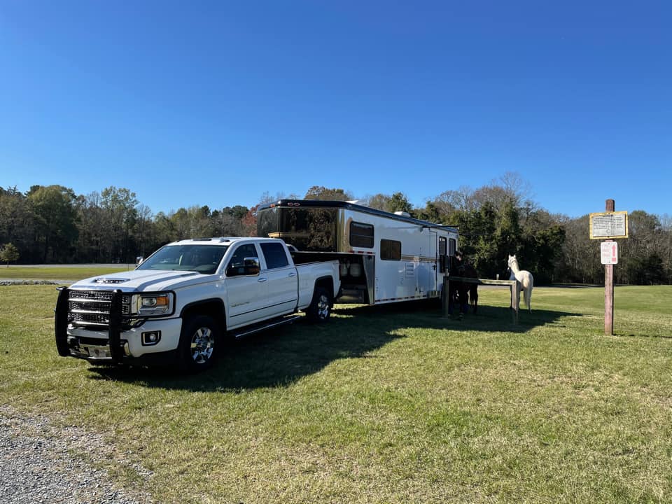 white chevy truck pulling a living quarters horse trailer