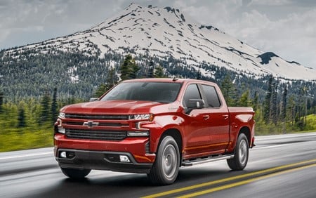 A red Chevrolet truck driving through the mountains