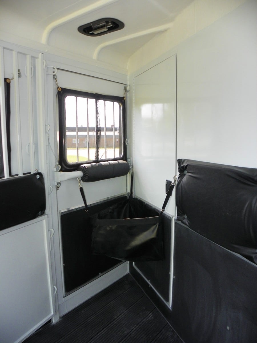 Feed bag inside of a horse trailer stall