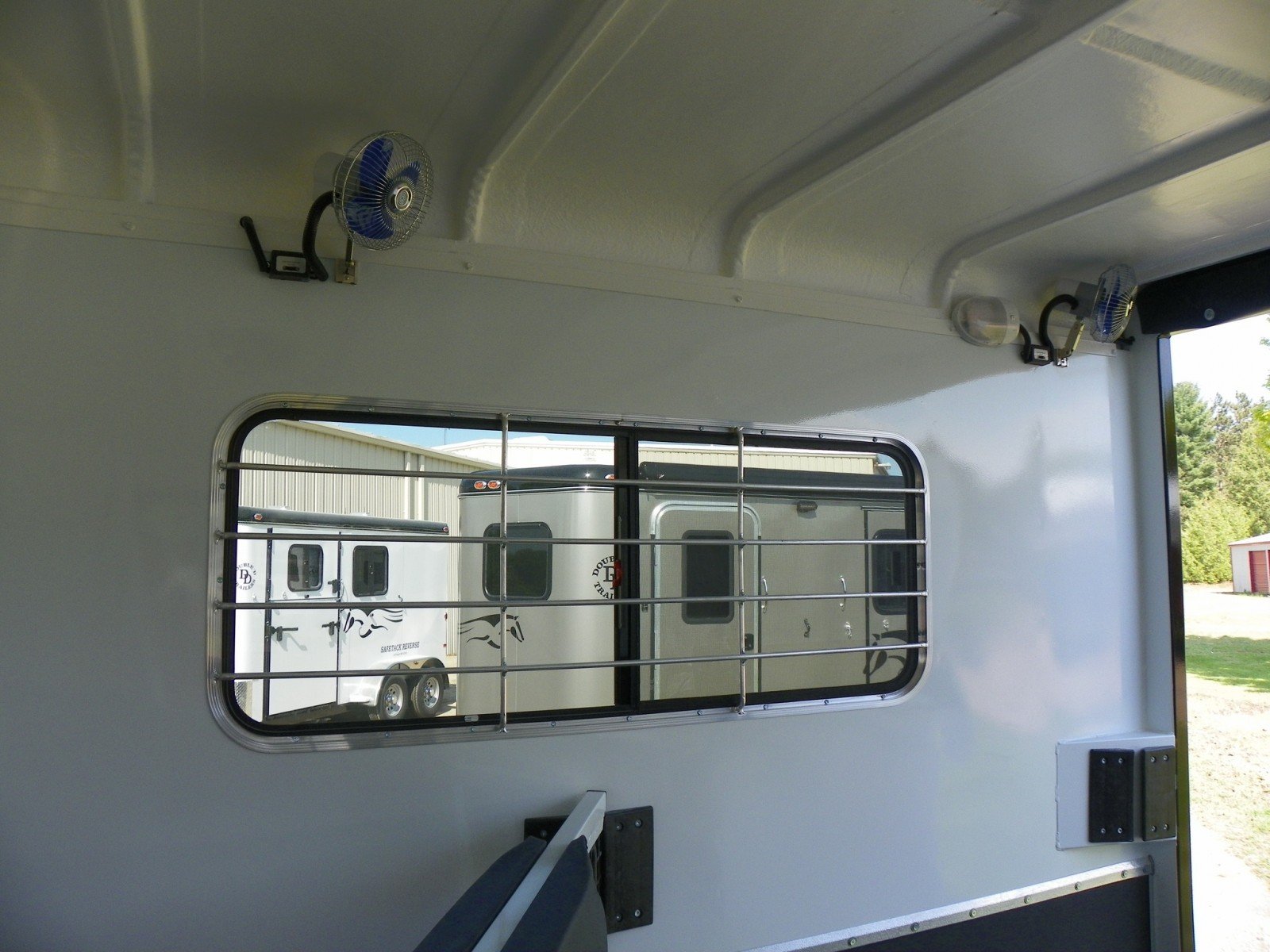 Fans inside of a horse trailer stall. 