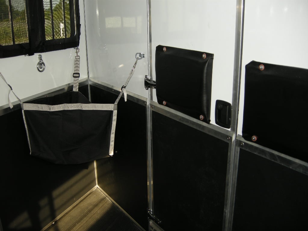 Feed bags inside of a horse trailer stall