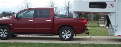 A red pickup truck hooked to a gooseneck trailer with a special hitch.