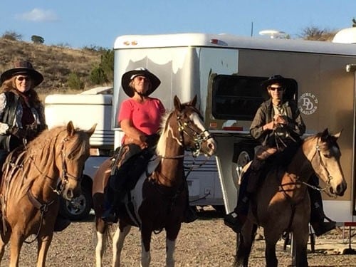 3 happy Double D Trailers owners on horseback enjoy the safety and easy towing of their V-nose gooseneck trailer.