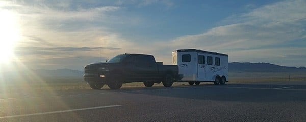 Double D Trailers Bumper Pull model hitched to a tow truck. 