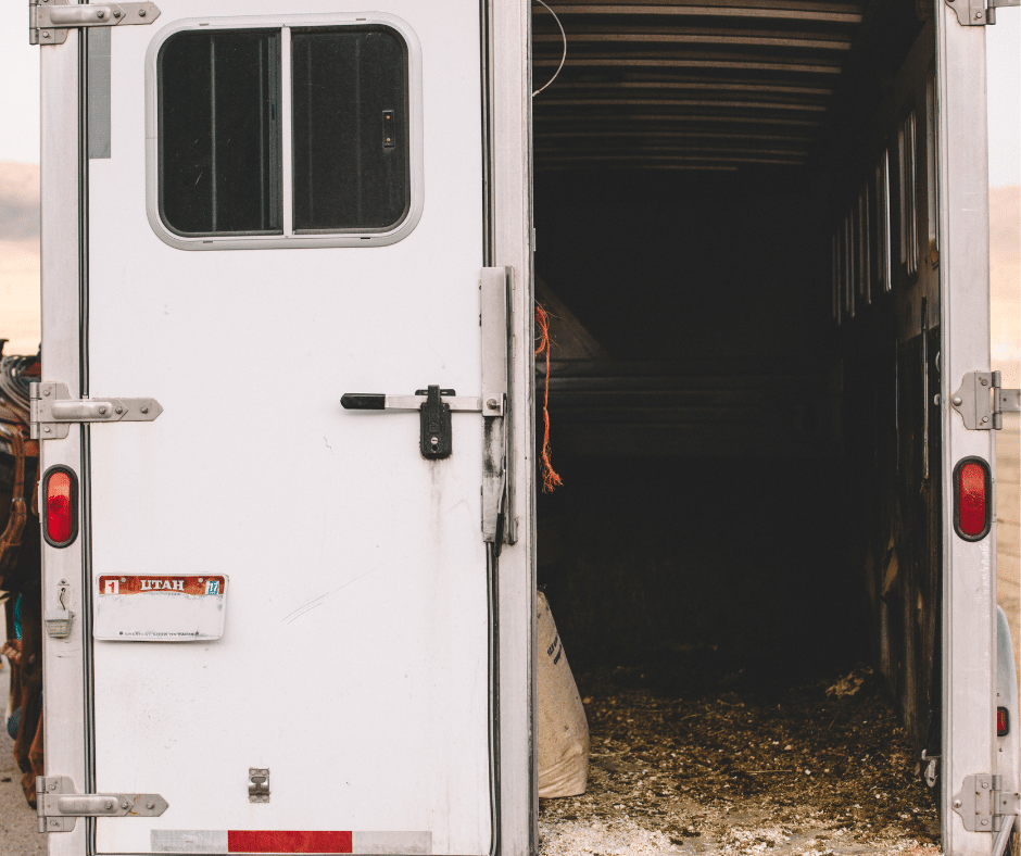 A dark and enclosed horse trailer stall makes a horse trailer uninviting for horses.