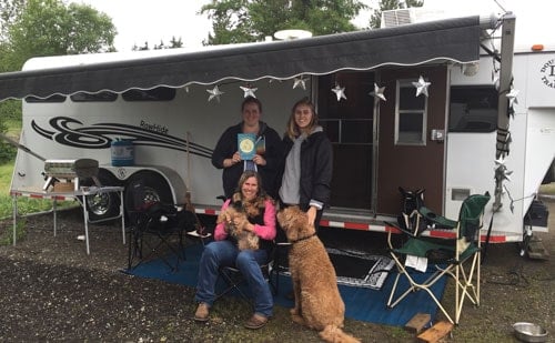 Double D Trailer owners posing outside of an older model trailer.