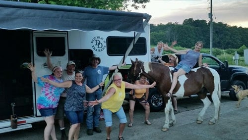 A group of people posed in front of a Double D Trailer