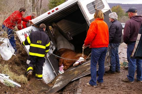 emergency crews on the scene of an overturned horse trailer in a horse trailer accident 