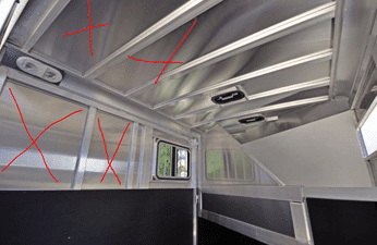 image of the interior walls of a horse trailer where the tubing frame is exposed with thin sheet metal