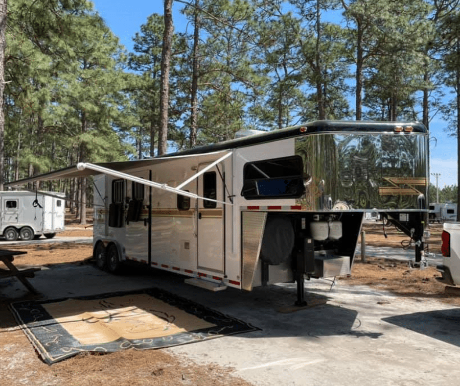 a horse trailer parked at a camping spot 
