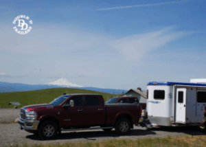 A Double D Trailer parked and attached to a tow vehicle.