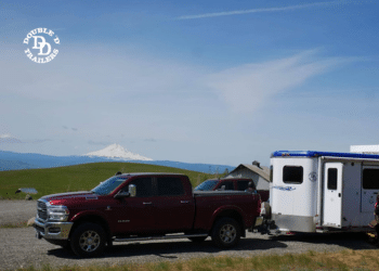 A Double D Trailer parked and attached to a tow vehicle.