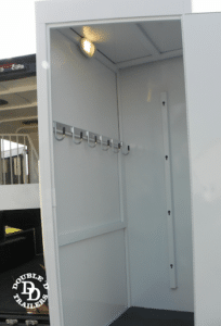 SafeTack swing-out trailer compartment with bridle hooks and a saddle rack.