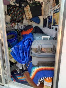 Interior of a horse trailer containing a selection of winter blankets and sheets designed for horse protection in trailers.