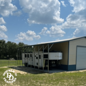 A Double D horse trailer covered under a storage shed.