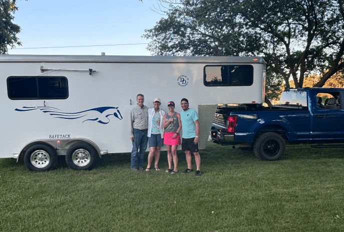 Happy Double D Trailers customers standing beside a gooseneck model. 