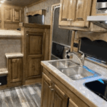 Photograph of a Double D trailer’s living quarters, showing a kitchenette, sleeping area, and storage space.